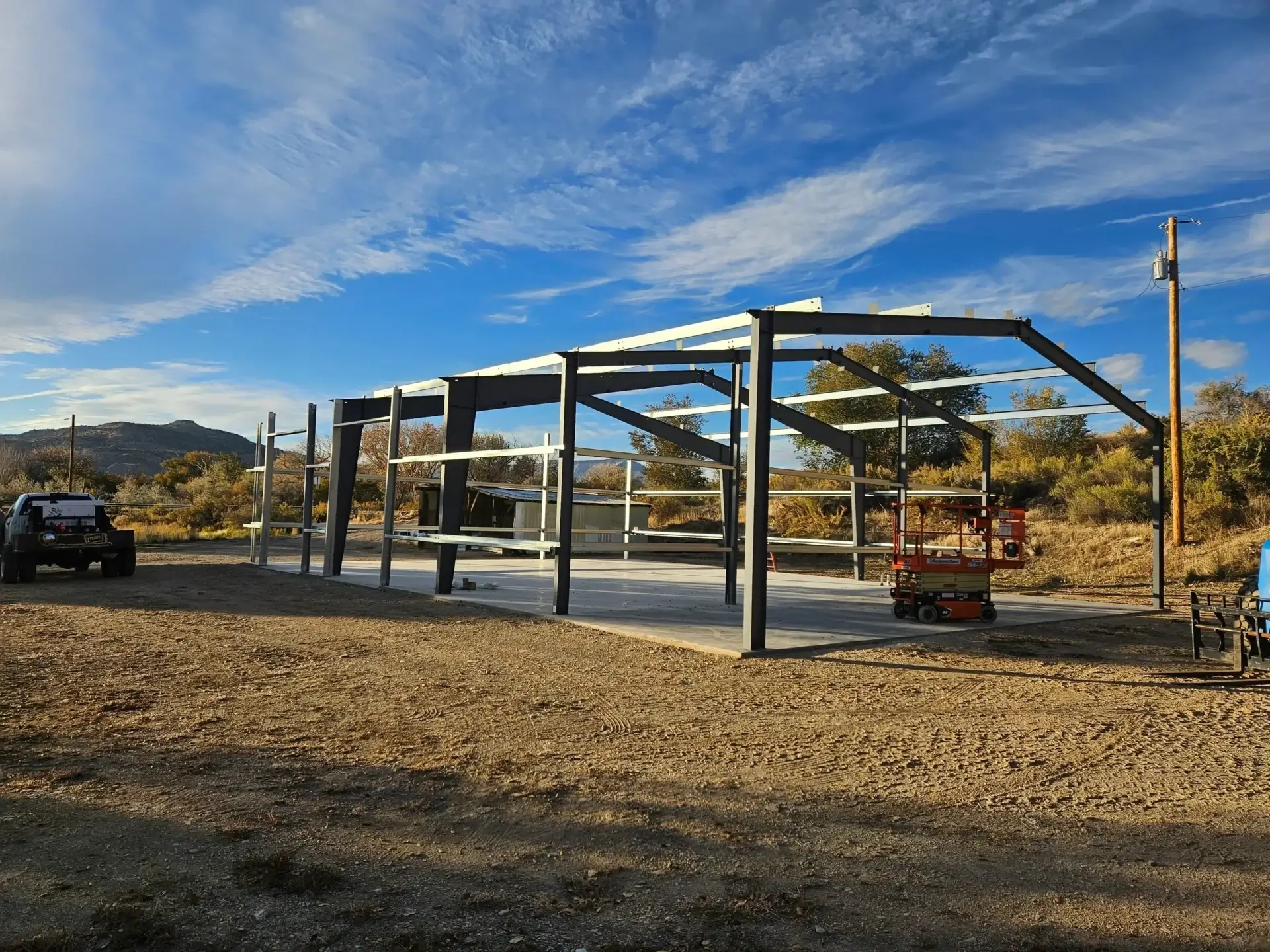 Steel framework of a building under construction in an open area.